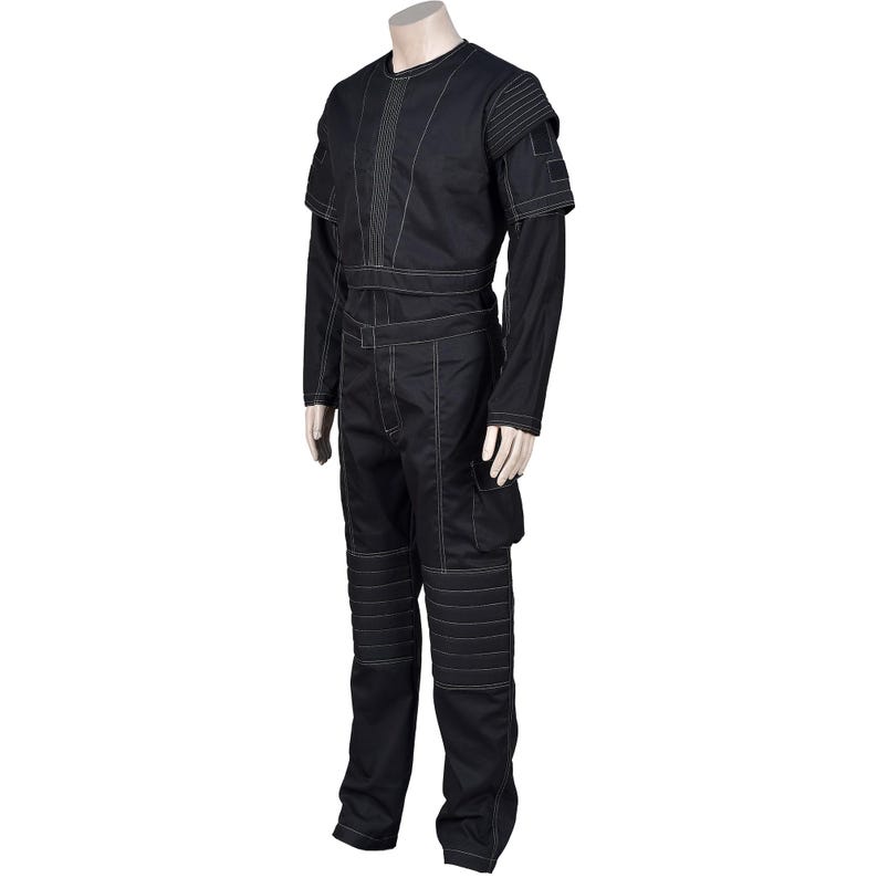 May include: Black jumpsuit with white stitching details. The outfit features a long-sleeved top with shoulder accents, a belted waist, and cargo pockets on the pants. The knees have reinforced panels. The garment is displayed on a mannequin.