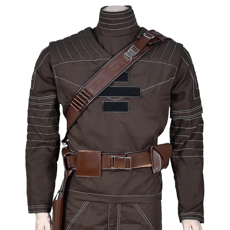 May include: Brown costume with a high collar, long sleeves, and white stitching details. It features a brown leather shoulder strap, belt, and pouches. The costume has a military or sci-fi theme.