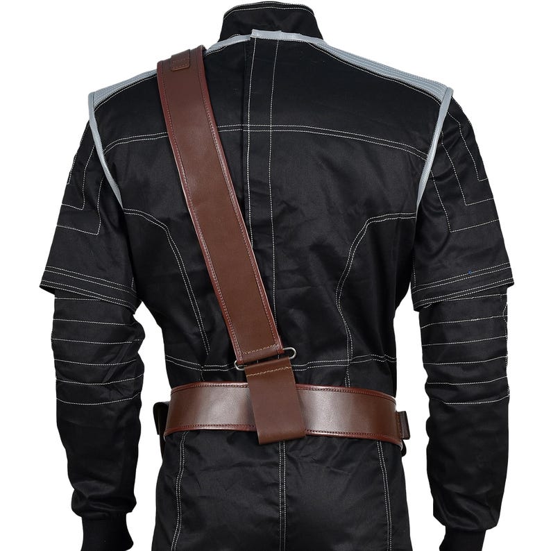 May include: Black jumpsuit with white stitching and gray accents. A brown leather belt and shoulder strap are visible. The jumpsuit has long sleeves and a high collar. The stitching creates a grid-like pattern across the garment.