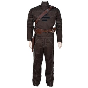 May include: A brown costume with white stitching, featuring a high collar, long sleeves, and matching pants. It includes a brown leather belt, shoulder strap, and holster. The outfit is displayed on a mannequin.