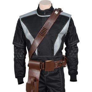 May include: Black jumpsuit with silver accents and brown leather accessories. The costume features a brown leather shoulder strap, belt, and pouches. The sleeves have geometric patterns and the suit has a high collar.