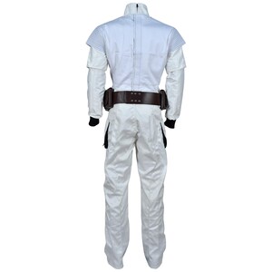 May include: A white jumpsuit with a high collar and a brown belt with pouches. The costume has black cuffs and a zipper down the front. The shoulders have a layered design.