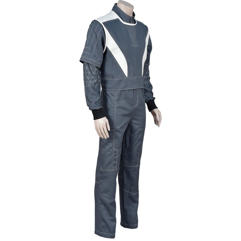 May include: A gray jumpsuit with white accents on the shoulders and chest. The suit has long sleeves with black cuffs and white stitching details. The mannequin is wearing a full body suit.