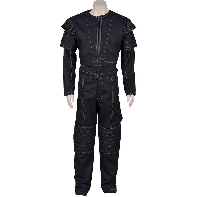 May include: Black jumpsuit with white stitching details. The outfit features a round neck, long sleeves, and a belt. The pants have knee padding and a side pocket. The shoulders have layered accents. The jumpsuit is displayed on a mannequin.