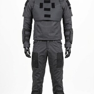 Pu&ograve; includere: Un set di uniforme tattica grigio scuro composto da una maglia a maniche lunghe con collo alto, imbottitura sulle spalle e una piastra pettorale con toppe rettangolari nere, abbinata a pantaloni coordinati con ginocchiere nere e tasche.