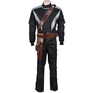 May include: Black jumpsuit with silver and gray accents, featuring a brown leather holster and shoulder strap. The costume includes a belt with pouches and a high collar. The sleeves have geometric patterns near the wrists, and the outfit is designed for a futuristic or sci-fi theme.