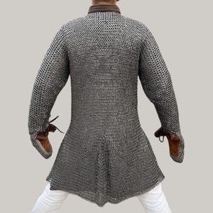 Model wearing aluminium chainmail hauberk with gloves at Renaissance fair, medieval cosplay armor