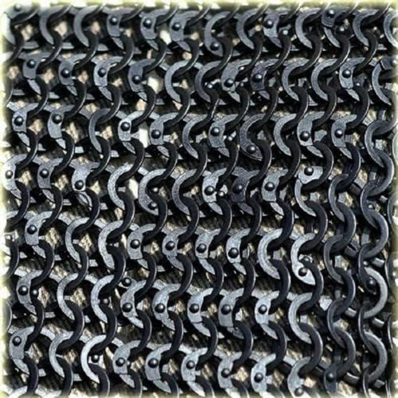 May include: Close-up of a section of chainmail armor. The interlocking metal rings are dark gray and arranged in a dense pattern. The links are riveted together, creating a flexible yet strong material. The overall texture is rough and metallic.