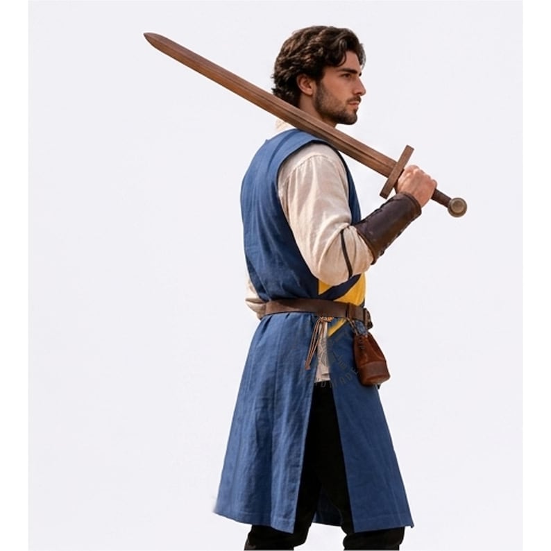 May include: A blue sleeveless tunic worn over a cream-colored long-sleeved shirt, paired with black trousers and a brown leather belt. A brown wooden sword is held over the shoulder, and a small brown leather pouch hangs from the belt.