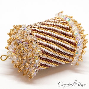 May include: A brown and white striped beaded ornament with gold accents and clear crystal beads. The ornament is shaped like a bell and has a gold loop at the top.