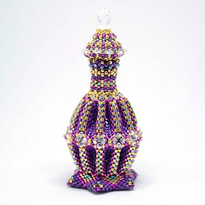 May include: A purple, gold, and teal beaded bottle with a star-shaped base and a clear crystal stopper.