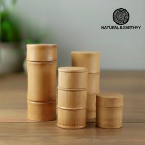 May include: Several bamboo storage containers with lids, in varying sizes and shapes. They have a natural wood finish. The logo "NATURAL & EARTHYY" is visible. These containers are suitable for storage.