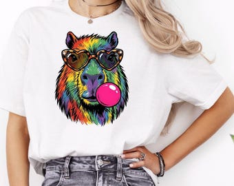 Maglietta da donna con capibara arcobaleno che soffia bolle di gomma e occhiali da civetta, regalo a tema animale.