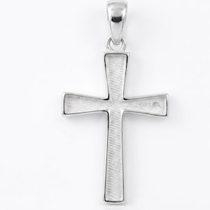 May include: A silver-toned cross pendant featuring a polished, smooth outer border and a textured, brushed finish on the interior surfaces of the cross arms. The pendant includes a small, rounded bail at the top for attachment to a chain or cord.