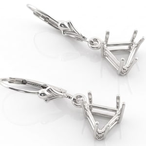 May include: A pair of silver-toned leverback earrings. Each earring features a decorative top, a hinged lever, and a triangular setting with four prongs. The settings are designed to hold a triangular gemstone. The earrings are displayed on a white background.