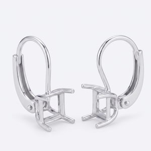 May include: A pair of silver leverback earring settings. Each setting features a square, open-frame design to hold a gemstone. The leverback closure is visible on each earring, designed for secure wear.