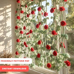 May include: Crocheted window curtain featuring red roses and green leaves. The curtain is made of yarn and hangs in front of a window. The text "FRIENDLY PATTERN PDF" and "INSTANT DOWNLOAD" are visible.