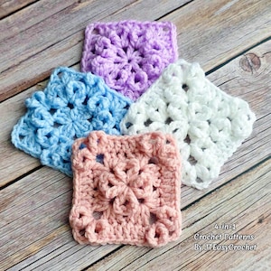 May include: Four crocheted squares in pastel colors: light blue, pink, purple, and white. Each square features a floral design. The squares are arranged on a wooden surface. Text in the image reads "4-in-1 Crochet Patterns By JTEasyCrochet."