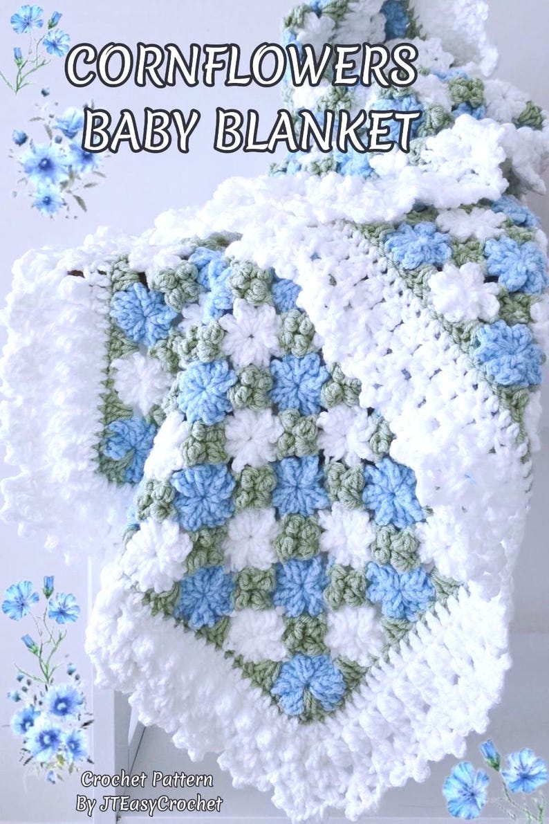 Lavishly beautiful crochet floral blanket made of cornflower motifs is hanging from a display. The blanket resembles a field of white and blue cornflowers framed with a beautiful lace edging.  The lettering says "Cornflowers Baby Blanket", "Crochet Pattern By JTEasyCrochet" meaning that JTEasyCrochet has the best crochet patterns for flower baby blankets, throws and afghans.