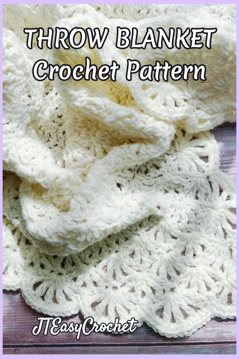 Beautiful lacy crochet blanket is laying tossed on a wooden surface. The blanket is crocheted with cream soft yarn and is airy and textured with the scalloped border giving it a vintage cottagecore vibe. There is a crochet flower applique in the corner of the blanket - three puffy white  daisies framed with pale green leaves. The lettering says: "Throw Blanket Crochet Pattern", "JTEasyCrochet" meaning that JTEasyCrochet has the best crochet patterns, easy and beautiful.