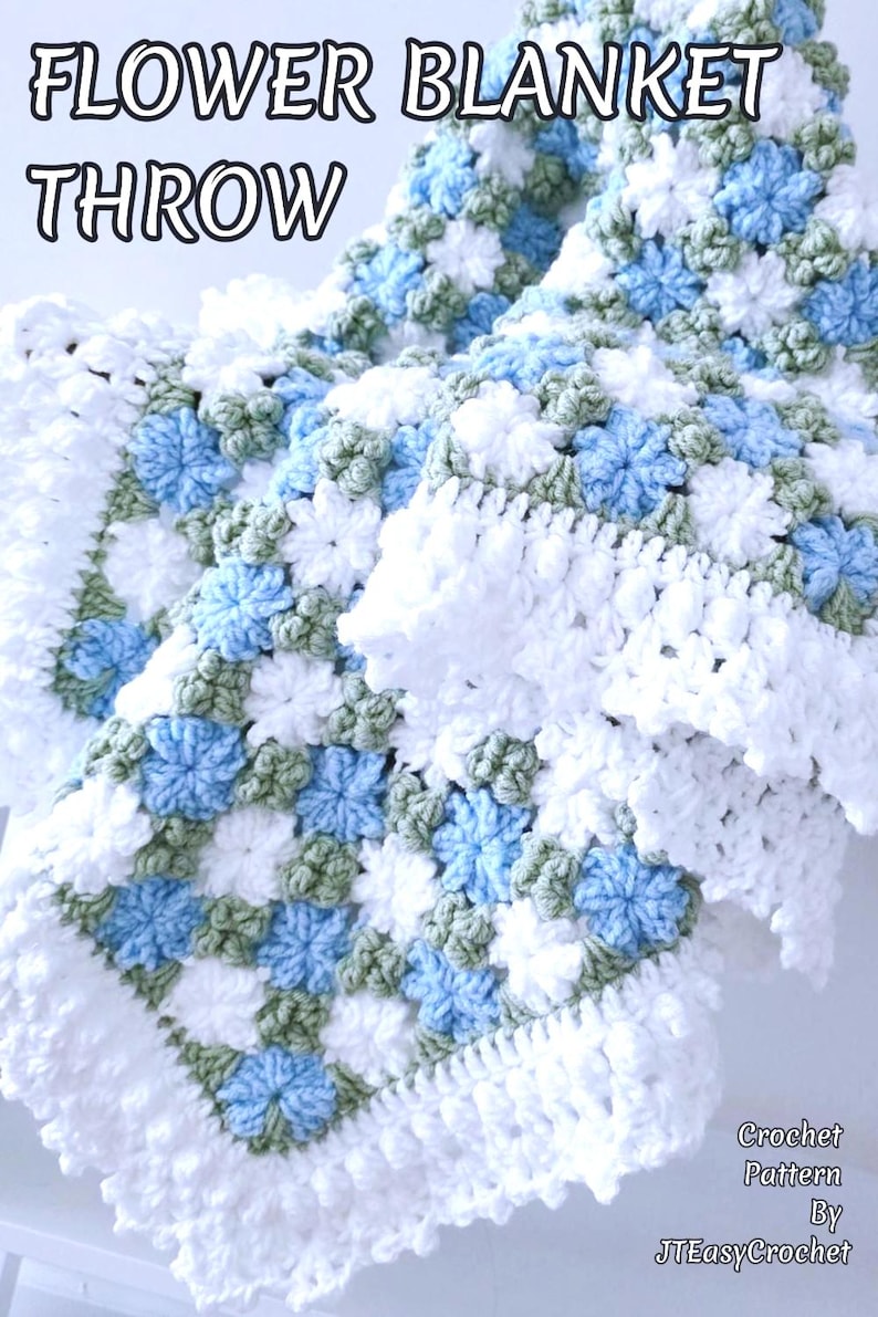 Lavishly beautiful crochet floral blanket made of cornflower motifs is hanging from a display. The blanket resembles a field of white and blue cornflowers framed with a beautiful lace edging.  The lettering says "Flower Blanket Throw", "Crochet Pattern By JTEasyCrochet" meaning that JTEasyCrochet has the best crochet patterns for flower baby blankets, throws and afghans.