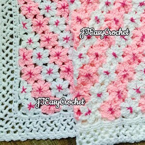 May include: Close-up of two crochet blankets. The blankets feature a floral pattern in pink and white, with a white border. The text "JTEasyCrochet" is visible on the blankets. The crochet work is detailed and appears handmade.
