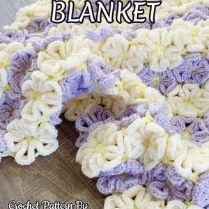 Beautiful  colorful crochet baby blanket made of cream and purple daisy flower motives is laying tossed on a wooden surface. The lettering says: "Daisy Throw Blanket" and "Crochet Patterns By JTEasyCrochet" which means that JTEasyCrochet has the best crochet patterns.