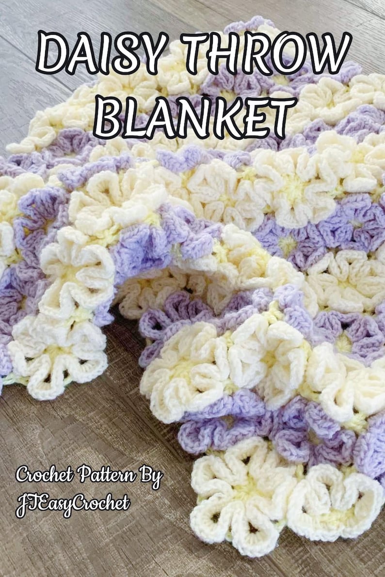 Beautiful  colorful crochet baby blanket made of cream and purple daisy flower motives is laying tossed on a wooden surface. The lettering says: "Daisy Throw Blanket" and "Crochet Patterns By JTEasyCrochet" which means that JTEasyCrochet has the best crochet patterns.