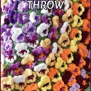 : Beautiful round crochet blanket or crochet rug is hanging from a display. The blanket is made of colorful pansy flowers arranged in circular pattern and the fringe og the blanket is made of green pansy leaves. The lettering says: "Pansy Flower Blanket", "Crochet Pattern By JTEasyCrochet" meaning that JTEasyCrochet has the best crochet patterns and fun crochet ideas.