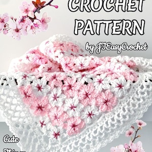 May include: A white and pink crocheted baby blanket with a floral pattern. The blanket is folded and displayed with cherry blossom branches. Text on the image reads "Baby Blanket Crochet Pattern by JEasyCrochet."