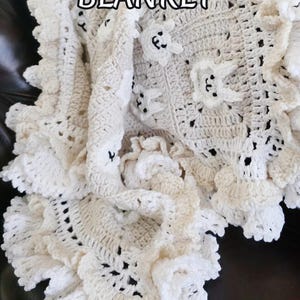 Beautiful Bunny  granny square blanket with fringed edging is laying on a dark leather couch. The blanket is cream with white bunnies on each square. The lettering says: “Bunny Baby Blanket”, “Crochet Pattern By JTEasyCrochet” meaning that JTEasyCrochet has the best crochet patterns and fun crochet ideas.