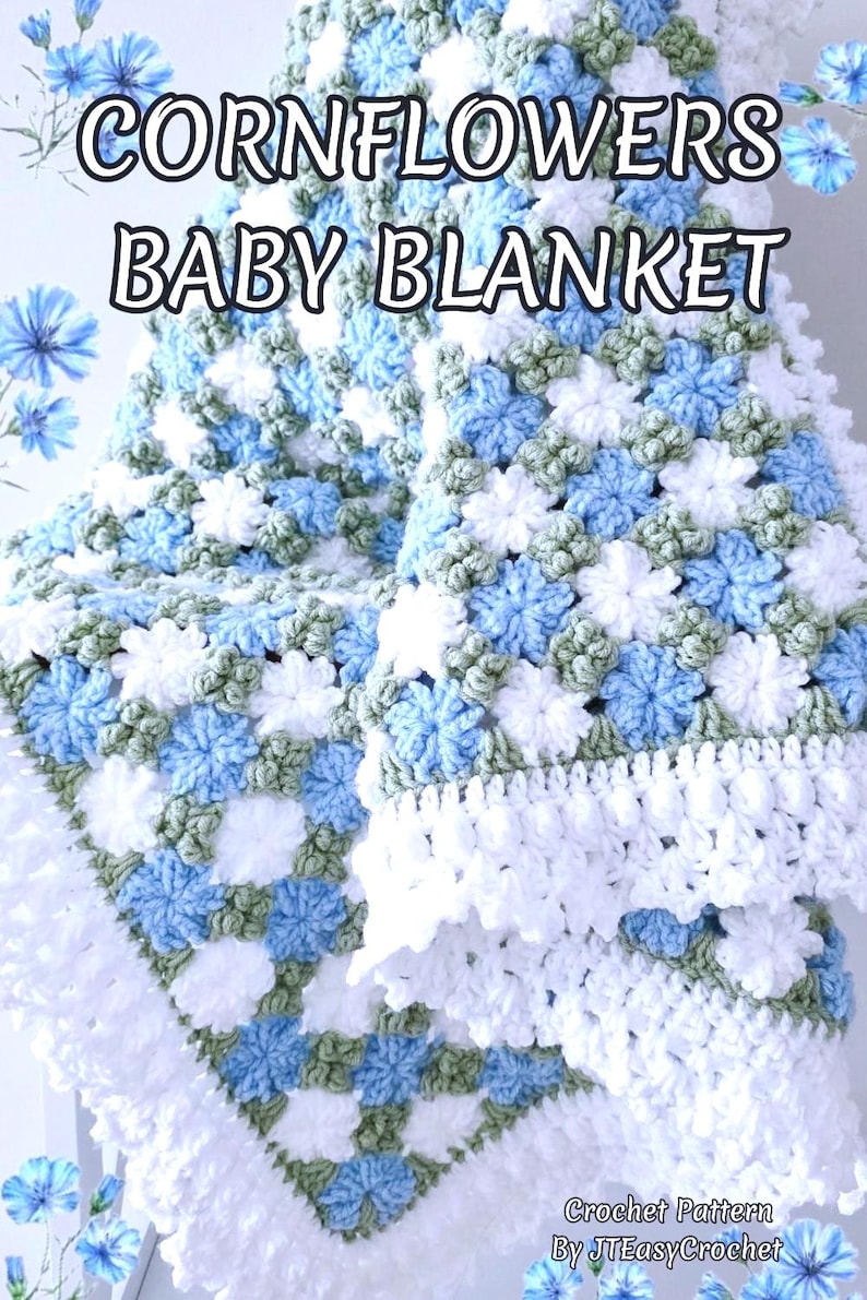 Lavishly beautiful crochet floral blanket made of cornflower motifs is hanging from a display. The blanket resembles a field of white and blue cornflowers framed with a beautiful lace edging.  The lettering says "Cornflowers Baby Blanket", "Crochet Pattern By JTEasyCrochet" meaning that JTEasyCrochet has the best crochet patterns for flower baby blankets, throws and afghans.