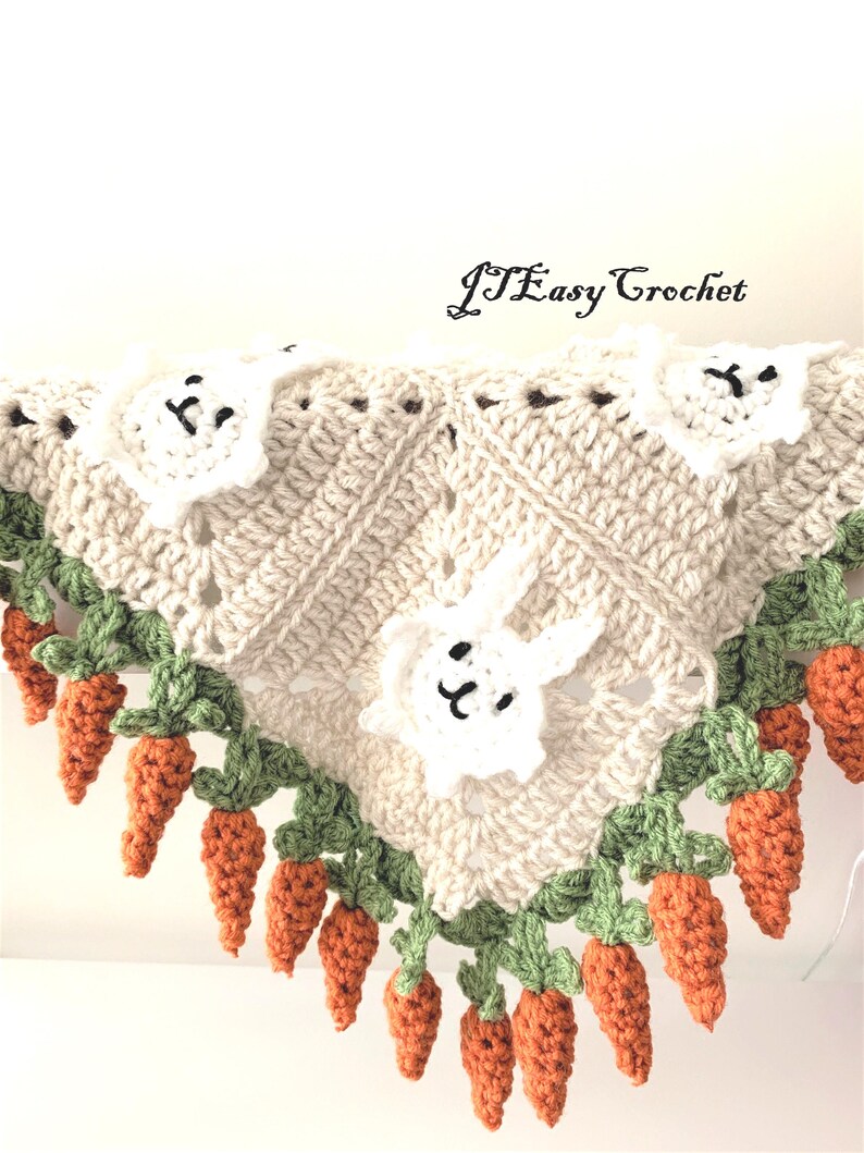 Puede incluir: Una manta de beb&eacute; tejida a crochet con un dise&ntilde;o de conejito blanco y zanahorias. La manta est&aacute; hecha con hilo beige, blanco, verde y naranja. El texto "JTEasy Crochet" es visible en la esquina superior derecha de la imagen.