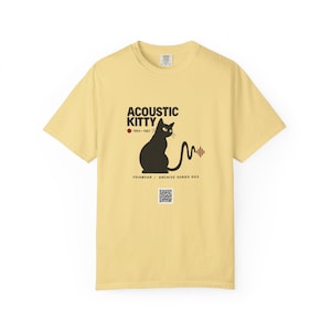 May include: A pale yellow short-sleeve t-shirt featuring a black cat graphic with the text "ACOUSTIC KITTY 1964-1967" and "FOIAWEAR / ARCHIVE SERIES 003". The cat's tail forms a sound wave pattern, and a small QR code is printed below the text.