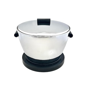 May include: A chrome-plated ice bucket with a black handle and side handles. The bucket sits on a black base and has a matching lid. The design is a classic, vintage style.