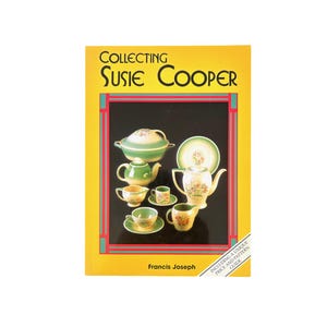 May include: A book titled "Collecting Susie Cooper" with a yellow cover and a black border. The cover features various pieces of Susie Cooper china, including teacups, teapots, and serving dishes. The book includes a price and pattern guide.