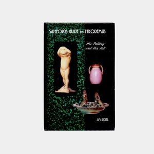 May include: A book cover with the title "Sanfords Guide to Nicodemus" and the subtitle "His Pottery and His Art." The cover features a statue, a pink vase, and a decorative bowl. The background is dark green.