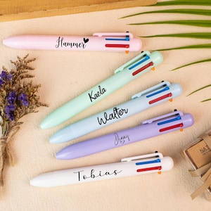 Könnte beinhalten: Fünf mehrfarbige Stifte in Pastelltönen von Rosa, Grün, Blau, Lila und Weiß. Jeder Stift hat einen anderen Namen darauf geschrieben: Hammer, Kaela, Walter, Denny und Tobias. Die Stifte haben rote, blaue und orangefarbene Tintenspitzen.