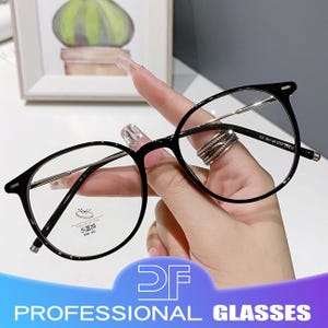 May include: Black, round-frame spectacles with clear lenses and silver-coloured arms. The text "PROFESSIONAL GLASSES" is displayed at the bottom of the image.