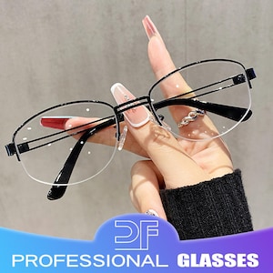 Puede incluir: Gafas con montura negra con un diseño de media montura. Las gafas tienen lentes transparentes y las sostiene una mano con uñas largas y cuidadas. El texto "PROFESSIONAL GLASSES" se muestra en la parte inferior.
