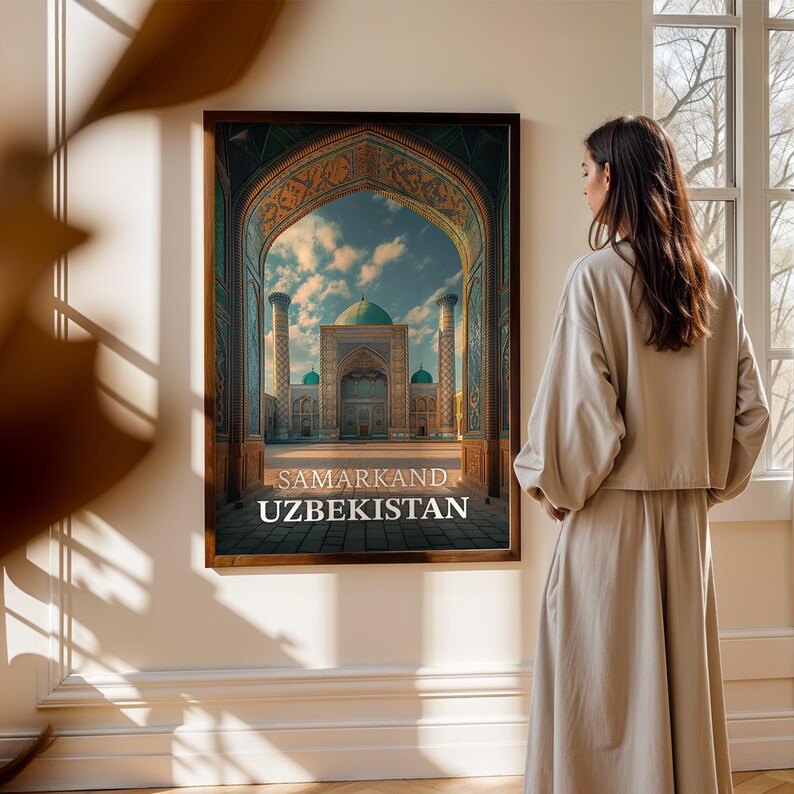 May include: A framed print of a building in Uzbekistan, featuring an arched entrance and a domed roof. The print has the words "SAMARKAND UZBEKISTAN" at the bottom. The print is hanging on a beige wall.