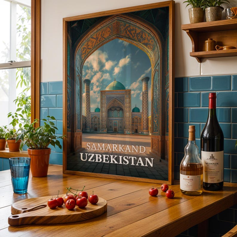 May include: Framed print of Samarkand, Uzbekistan, featuring a detailed architectural view through an archway. The image showcases a mosque with turquoise domes and minarets. The print is displayed on a wooden surface with wine bottles, a glass, and cherries.