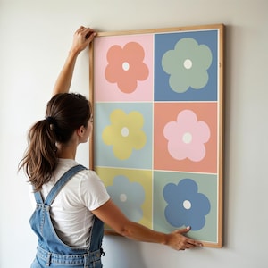 May include: A framed art print featuring a grid of six colorful flower illustrations. Each flower has a white center and is set against a different pastel background. The frame is made of light-colored wood.