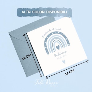 Op de afbeelding: Een lichtblauwe wenskaart met bijpassende envelop. De kaart, met een afmeting van 12 cm x 12 cm, heeft een blauw regenboogontwerp en de tekst "Benvenuto al mondo" en "Federico, 1 luglio 2025". De tekst "Altri Colori Disponibili" is ook zichtbaar.