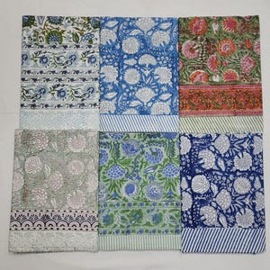 May include: A collection of six rectangular fabric pieces with floral patterns in various colors. The designs include blue, green, and red floral prints with white accents. Each piece has a patterned border and a striped bottom.