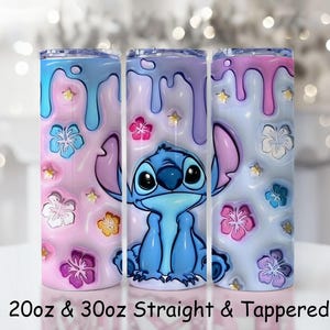 May include: Three stainless steel tumblers with a colorful design featuring the character Stitch from Lilo & Stitch. The tumblers have a pink, blue, and purple color scheme with floral and star accents. The text "20oz & 30oz Straight & Tapered" is at the bottom.
