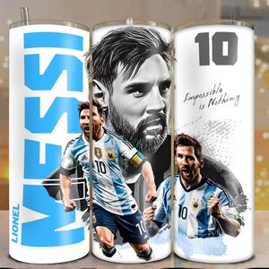 May include: White stainless steel tumbler featuring images of Lionel Messi in an Argentinian soccer uniform. The tumbler has the word "MESSI" in large blue letters and the text "Impossible is Nothing".