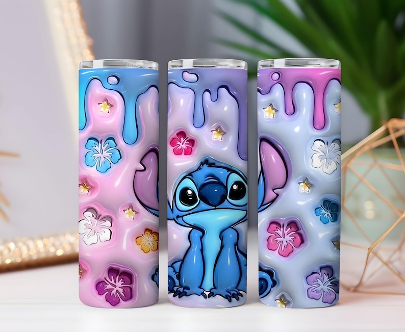 May include: Three 20 oz. insulated tumblers with a cartoon Stitch design. The tumblers feature a pink, blue, and purple color scheme with floral and star accents. The design includes a 3D effect with dripping paint.