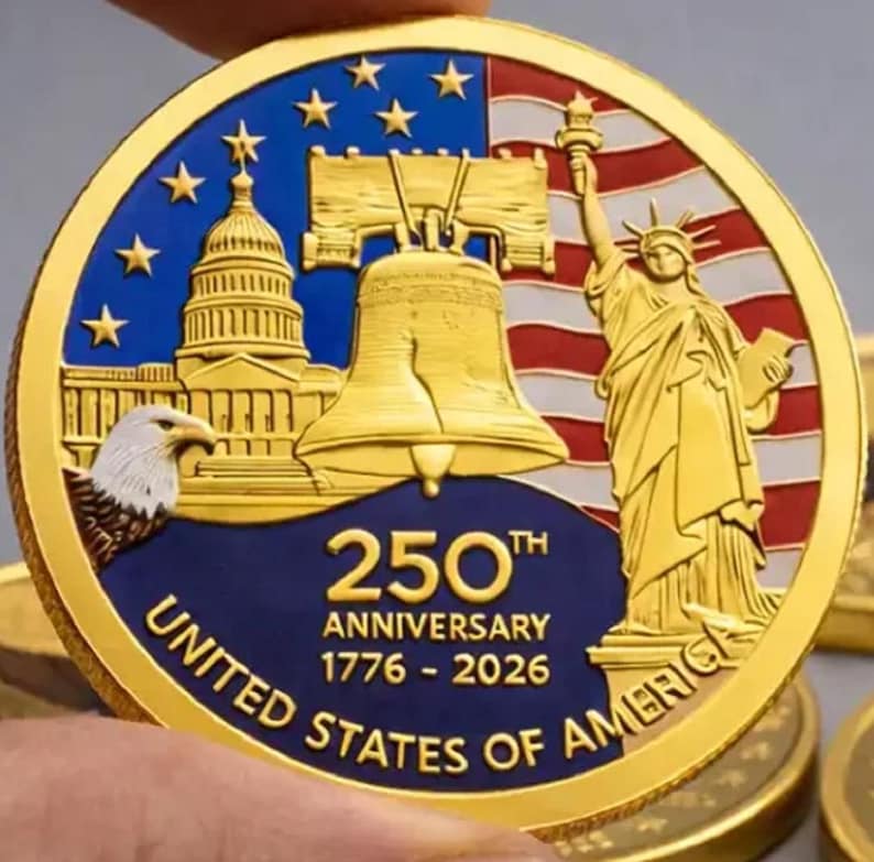 Pu&ograve; includere: Una moneta commemorativa dorata che celebra il 250&deg; anniversario degli Stati Uniti d'America. La moneta presenta il Campidoglio, la Liberty Bell, la Statua della Libert&agrave; e un'aquila. Il testo recita "250th Anniversary 1776-2026 United States of America."