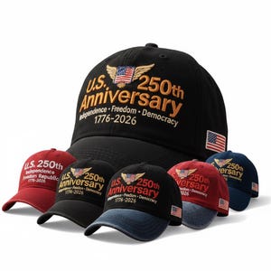 May include: A collection of baseball caps in various colors, including black, red, and navy blue. Each cap features the text "U.S. 250th Anniversary" with an American flag design and the years 1776-2026. The caps are embroidered.